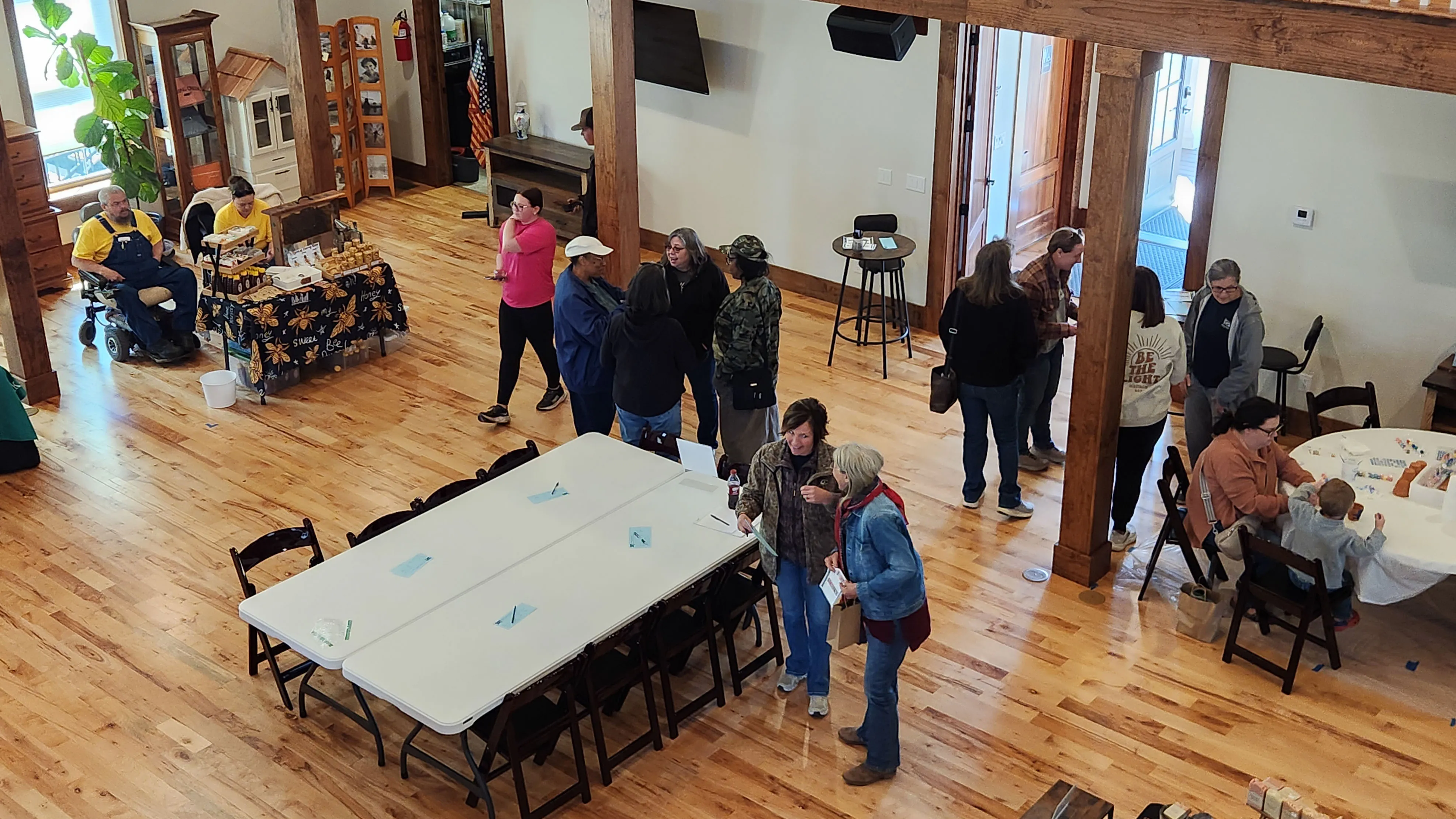 Visitors mill about the hall at Seed Swap 2026, with a long white table set up in the middle of the floor.