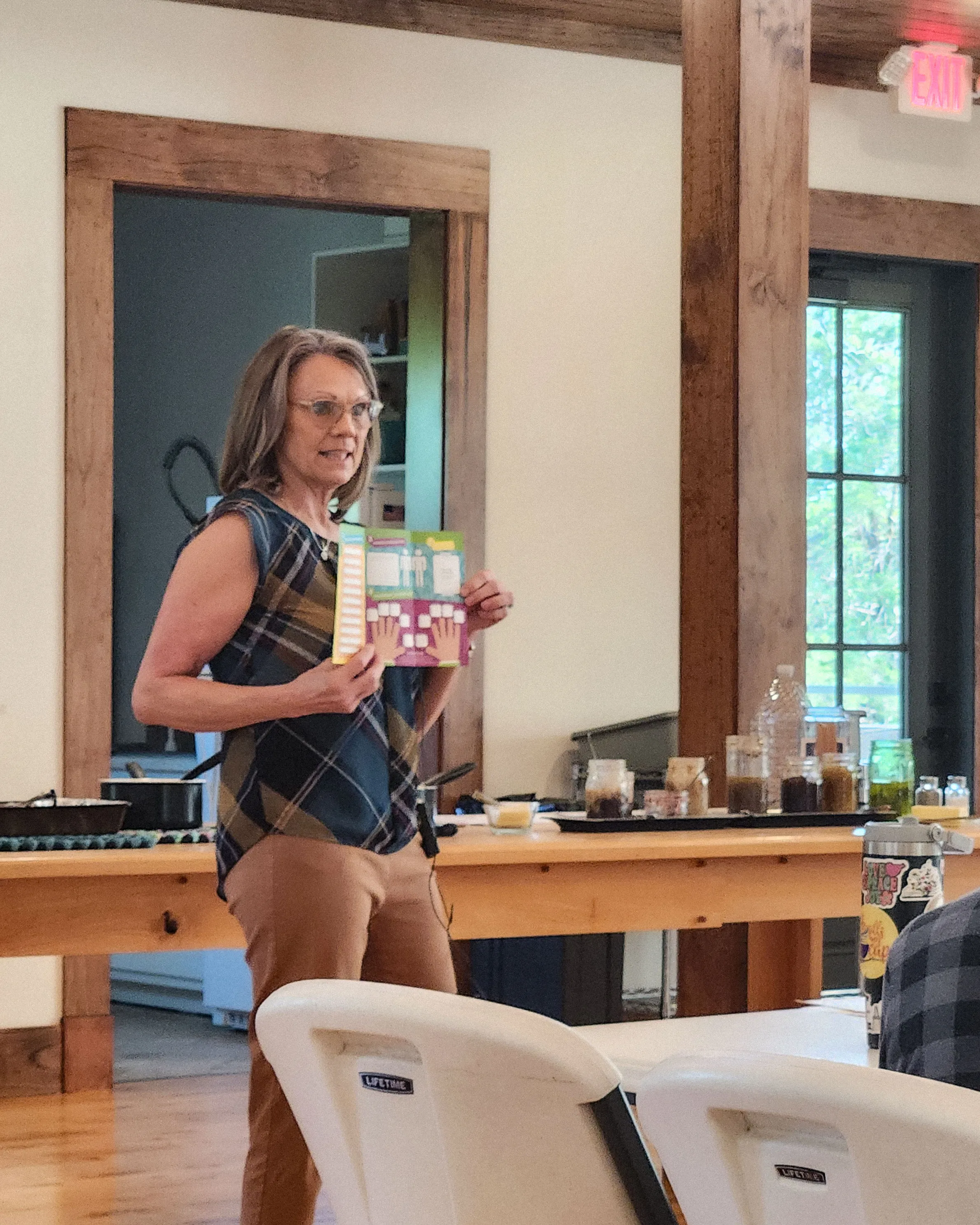 Kim Powell holds up a brochure while presenting.