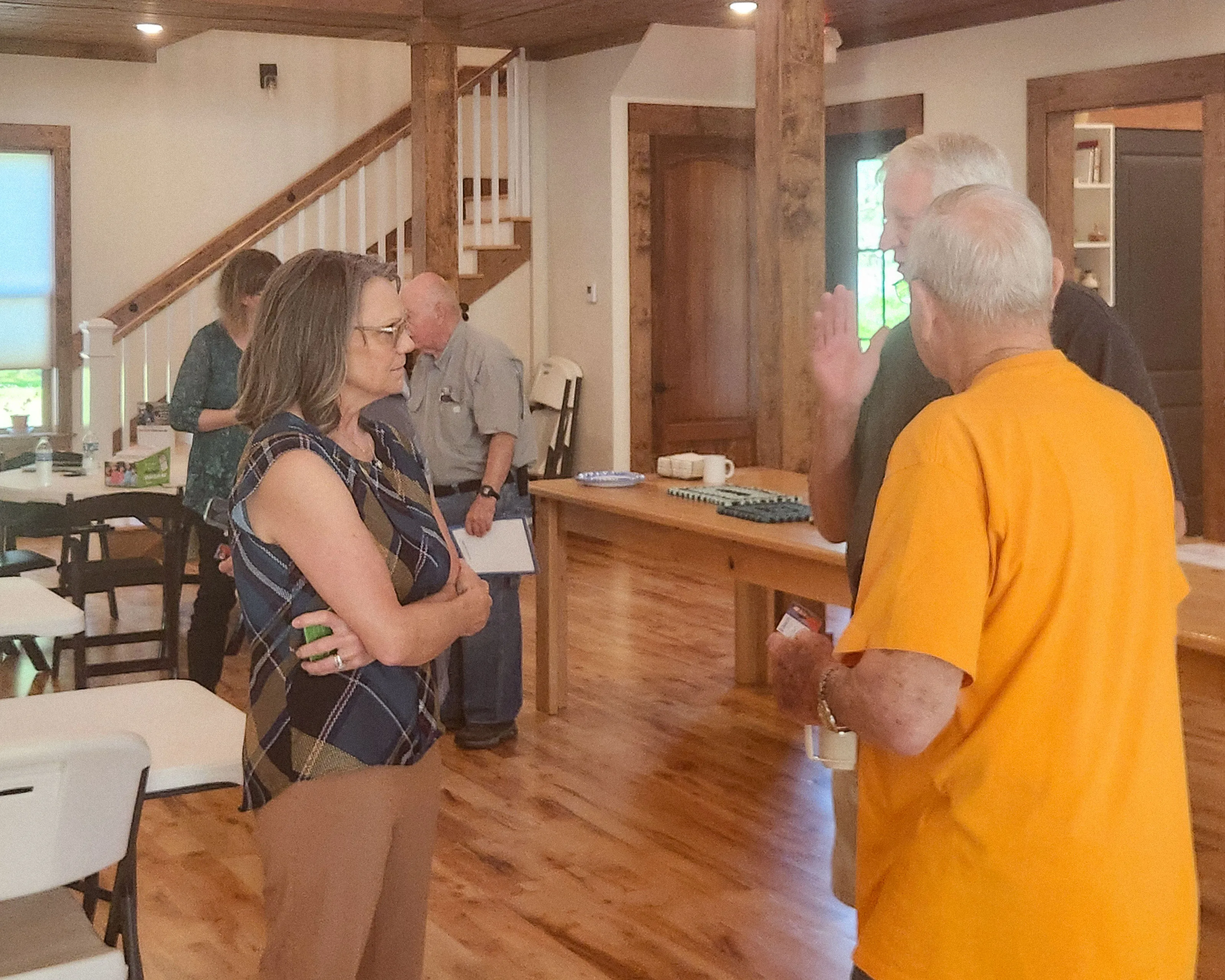 Kim Powell talks with a man in a yellow shirt at the breakfast.